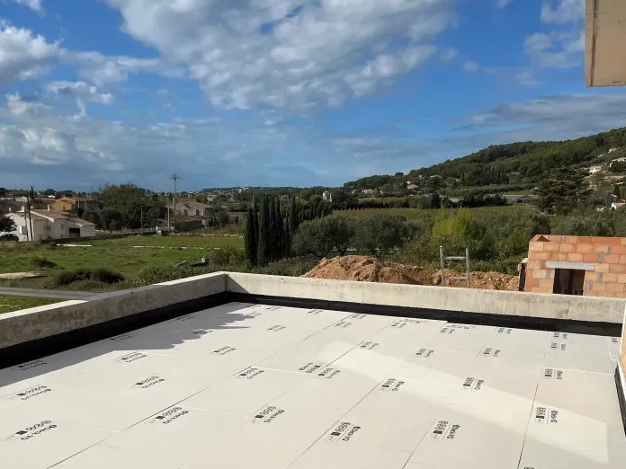 Rooftop terrace with scenic view of hills and cloudy sky.
