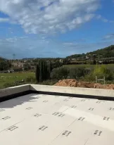 Rooftop terrace with scenic view of hills and cloudy sky.