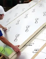 Worker in hard hat installing insulation panels on a roof.