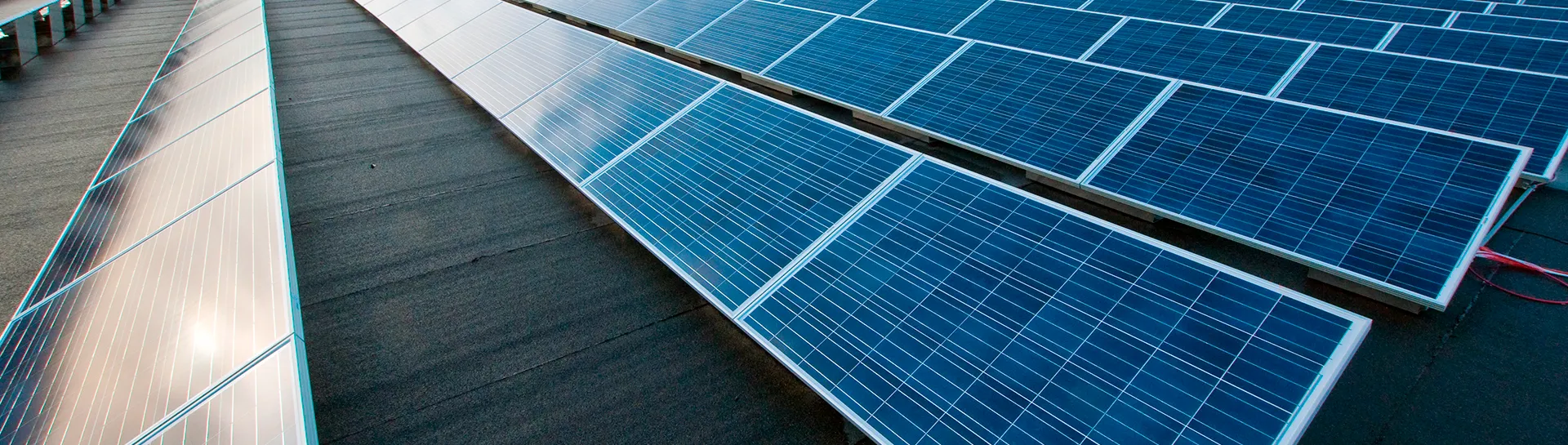 Aurinkopaneelit rivissä sinisen taivaan alla.