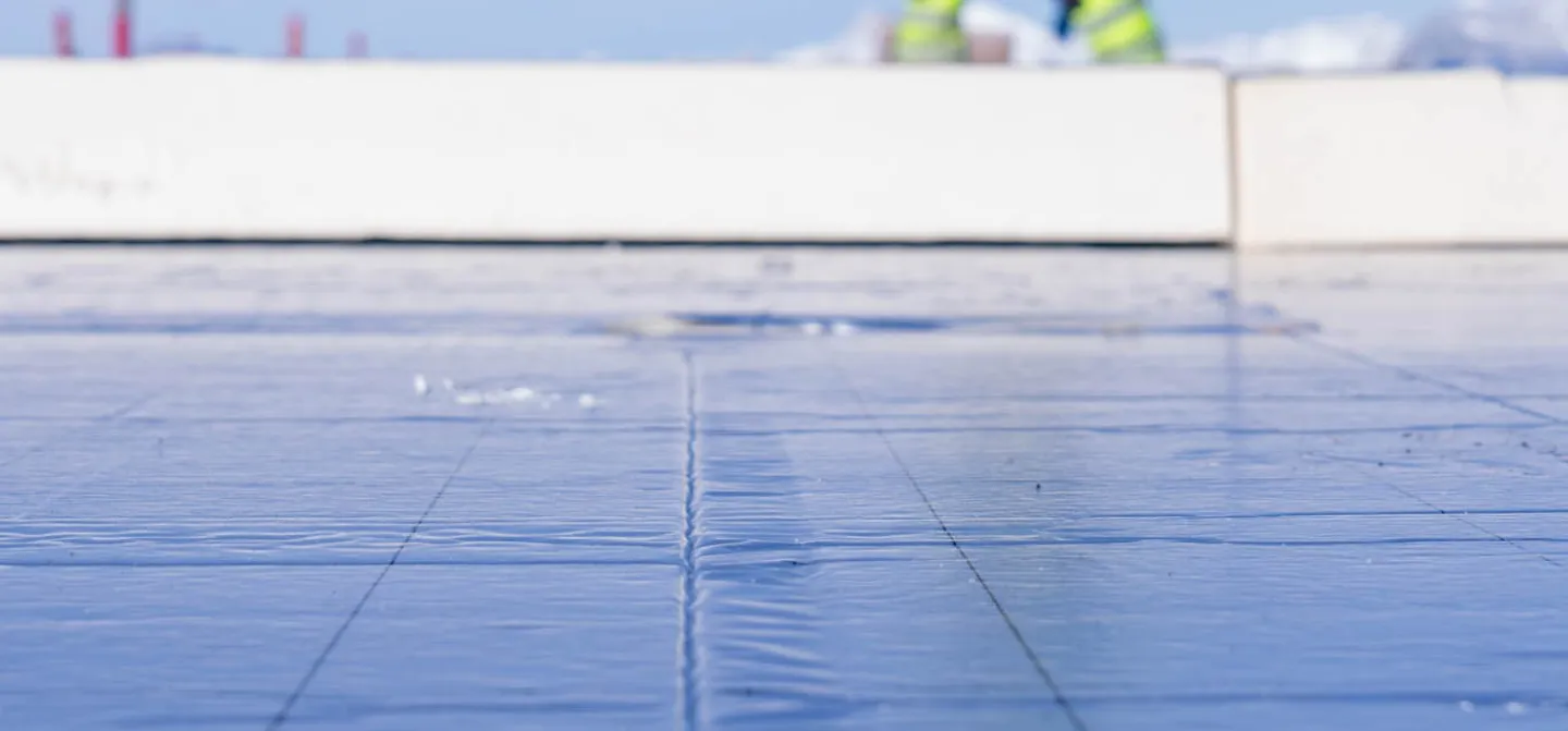 man loopt op geïsoleerd plat dak met Recticel Insulation