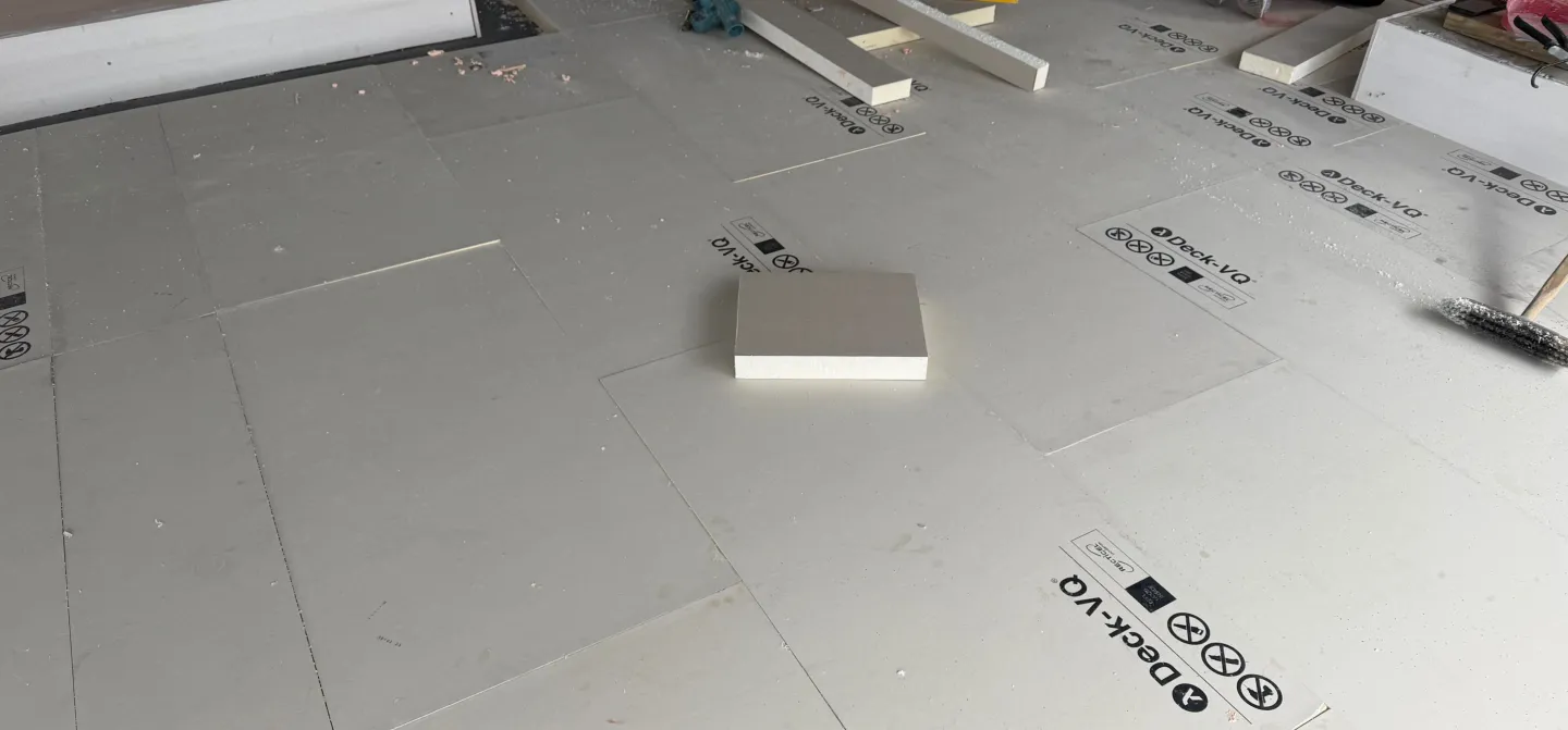 Construction workers installing foam insulation boards on the floor.