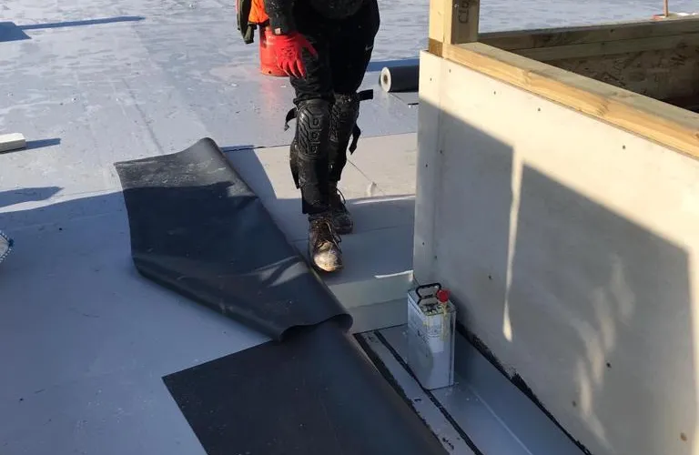 Contractor installing Powerdeck F within single ply membrane waterproofing system
