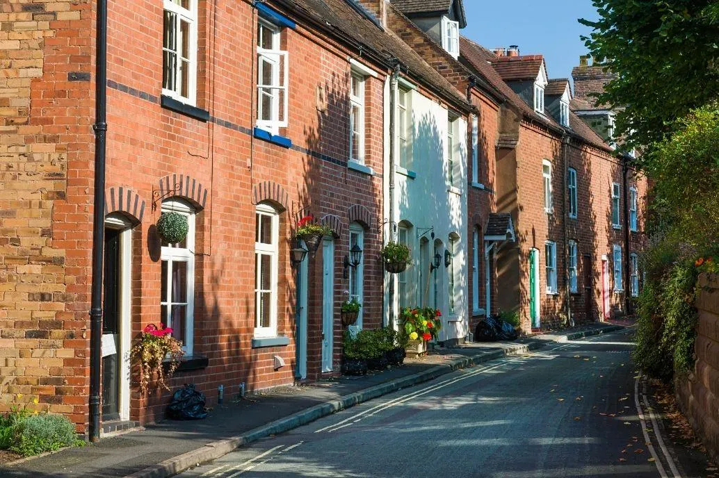UK housing street with trees and green space opposite promoting low carbon homes