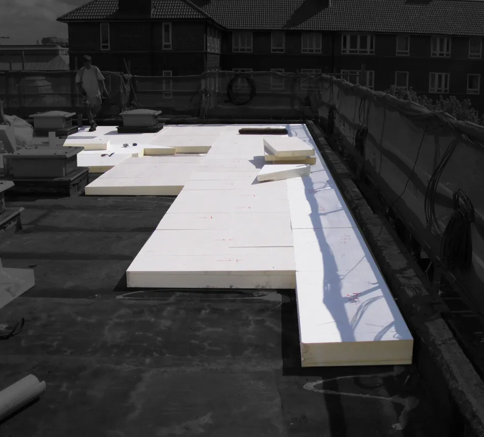 Flat roof with large white insulation panels laid out.