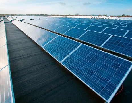 Aurinkopaneelit rivissä sinisen taivaan alla.