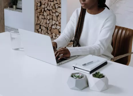 Woman in white long sleeve shirt with laptop