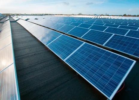 Aurinkopaneelit rivissä sinisen taivaan alla.