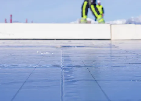 man loopt op geïsoleerd plat dak met Recticel Insulation