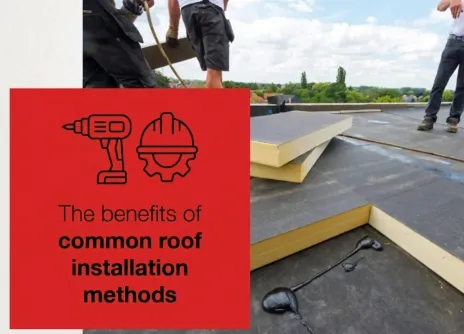 Roofers installing insulation panels on a flat roof.